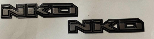EMBLEMA NKD GRIS RATON
